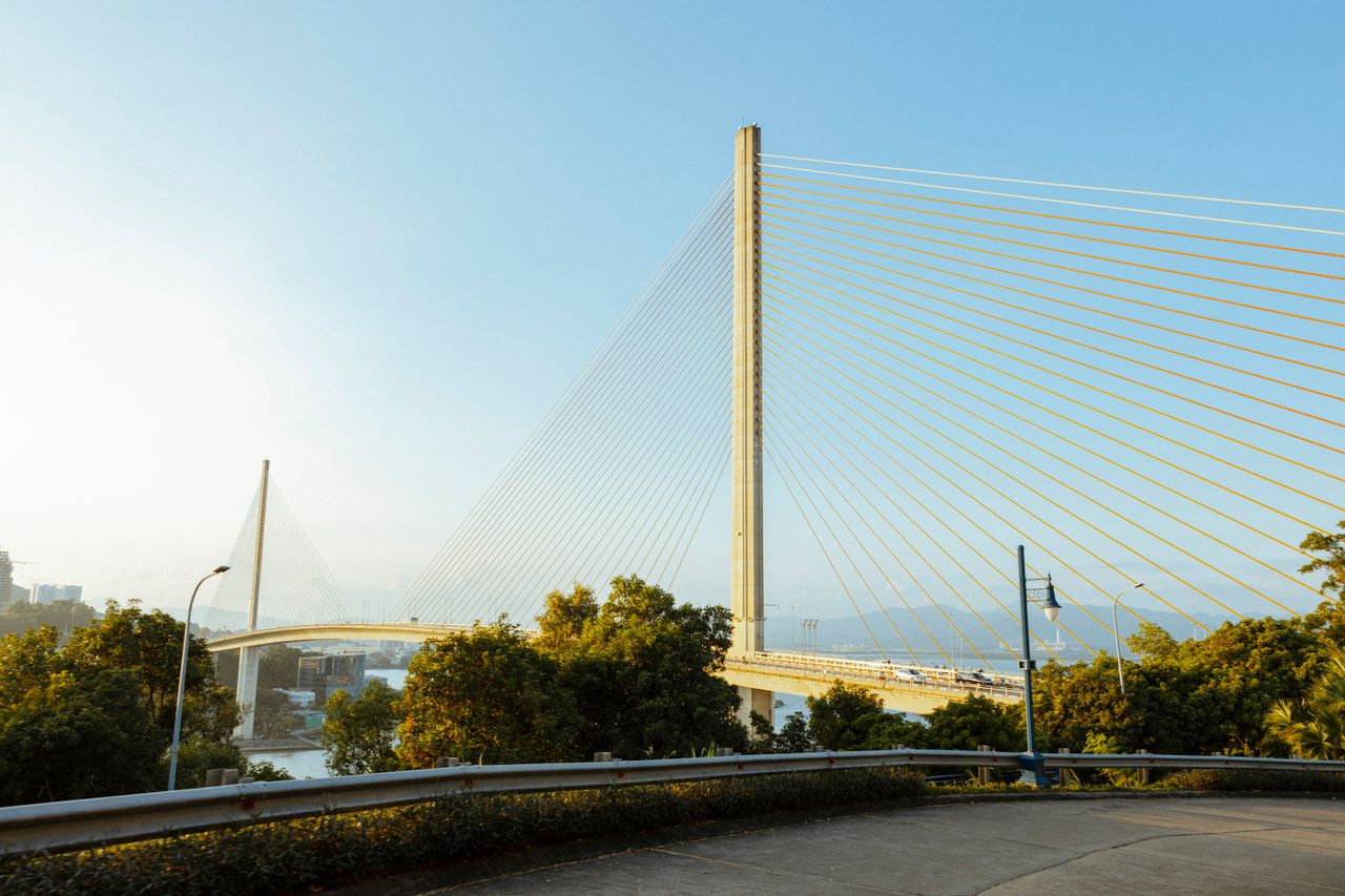 A stunning cable-stayed bridge spanning the river, surrounded by lush greenery.