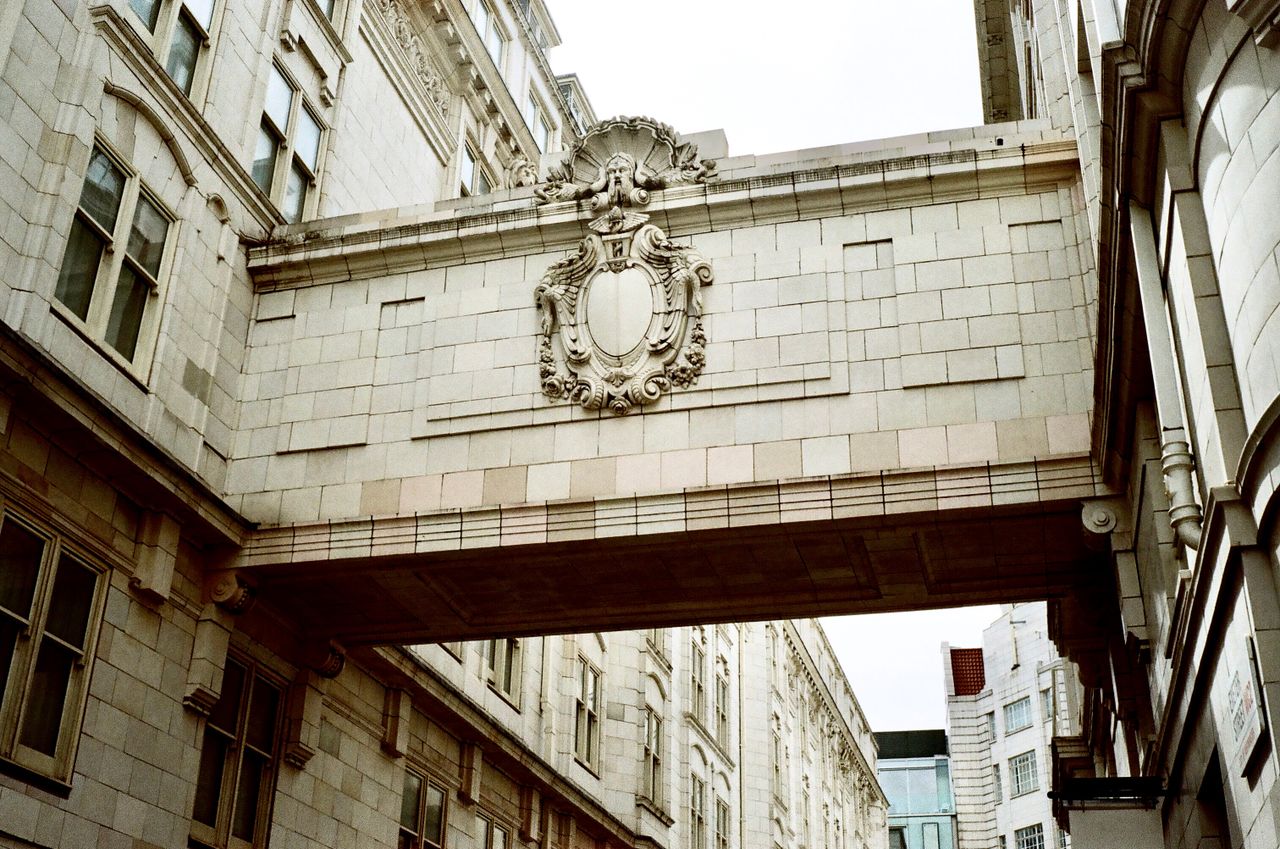 Ornate architectural bridge connecting classic buildings in city setting.